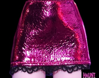 Puede incluir: Minifalda rosa fucsia brillante con superficie texturizada y ribete de encaje negro. La falda forma parte de un conjunto de moda. El texto "HAUNT COUTURE" es visible en la esquina inferior derecha.
