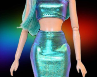 Puede incluir: Un conjunto de top corto y falda de color verde azulado iridiscente para una muñeca. El top es sin tirantes y la falda es una minifalda.
