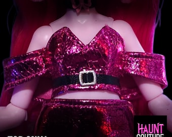 Puede incluir: Un atuendo de muñeca magenta con un top texturizado con hombros descubiertos y una falda a juego. El top tiene un cinturón negro con una hebilla plateada. El texto "TOP ONLY" está en la parte inferior izquierda y "HAUNT COUTURE" en la parte inferior derecha.