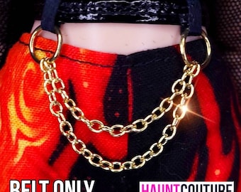 May include: A black leather belt with a gold chain attached. The chain is double-layered and has large, round links. The belt is worn over a red and black patterned fabric.