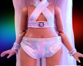 May include: A white iridescent swimsuit with a criss-cross halter top and a high-waisted bottom. The swimsuit has a silver buckle detail at the waist.
