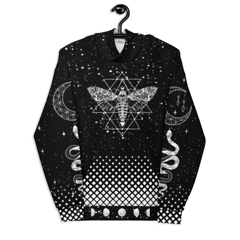 Peut inclure: Sweat-shirt &agrave; capuche noir avec un motif g&eacute;om&eacute;trique blanc repr&eacute;sentant un papillon de nuit, un serpent et une lune croissante. L'arri&egrave;re-plan est un motif &eacute;toil&eacute; noir et blanc.