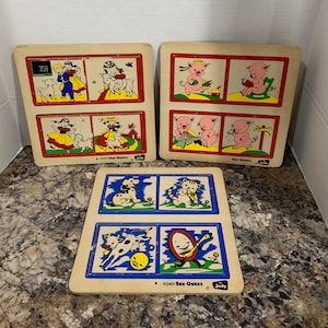May include: Three vintage wooden See-Quees puzzles featuring colorful illustrations of farm animals. The puzzles are labeled "See-Quees" and "Judy".