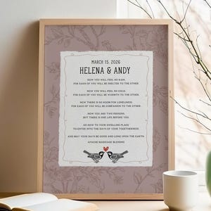 May include: A framed print featuring the Apache Marriage Blessing with the names Helena & Andy and the date March 15, 2026. The text is centered on a white background with a mauve floral border, including two birds and a small red heart.