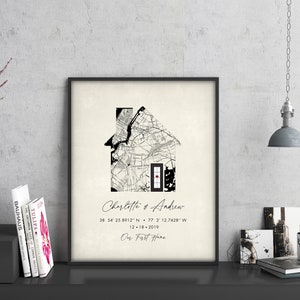 May include: A black and white map of a city is shaped like a house with a red heart in the center. The text below reads "Charlotte & Andrew 38 54 25.8912" N 77 2' 12.7428" W 12.18.2019 Our First Home".