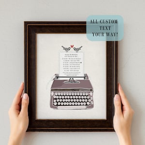 May include: A framed print featuring a vintage typewriter illustration. The print includes custom text with dates and events, topped with two bird illustrations and a heart. The frame is dark brown, and the text reads "ALL CUSTOM TEXT YOUR WAY!"