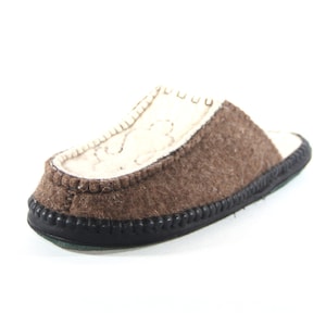 Pode incluir: Uma pantufa de feltro marrom com sola de borracha preta. A pantufa tem um forro de feltro branco e uma borda costurada.