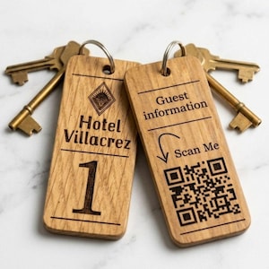 May include: Two wooden hotel key fobs with brass keys. One fob reads "Hotel Villacrez" and the number "1". The other has "Guest information" and a QR code with "Scan Me".