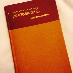 May include: A burgundy and orange hardcover book titled "Afterwhiles &" by James Whitcomb Riley.