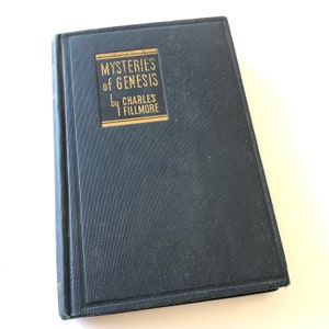 May include: A dark blue hardcover book with gold lettering on the spine and front cover. The title is "MYSTERIES of GENESIS" by CHARLES FILLMORE.