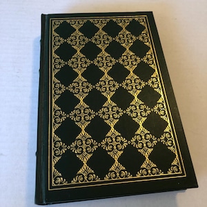 May include: A hardcover book with a dark green cover and gold decorative pattern. The pattern is a repeating diamond design with floral accents. The edges of the book are also dark green.