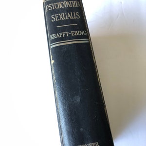 May include: A vintage book titled "Psychopathia Sexualis" by Krafft-Ebing. The book has a dark blue cover with the title and author's name in white lettering. The word "Pioneer" is printed at the bottom.