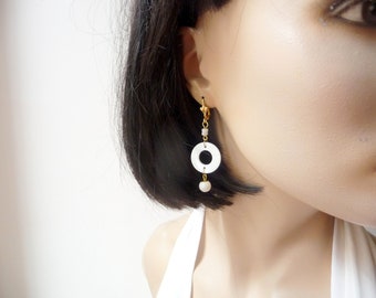 White earrings, mother-of-pearl ring.