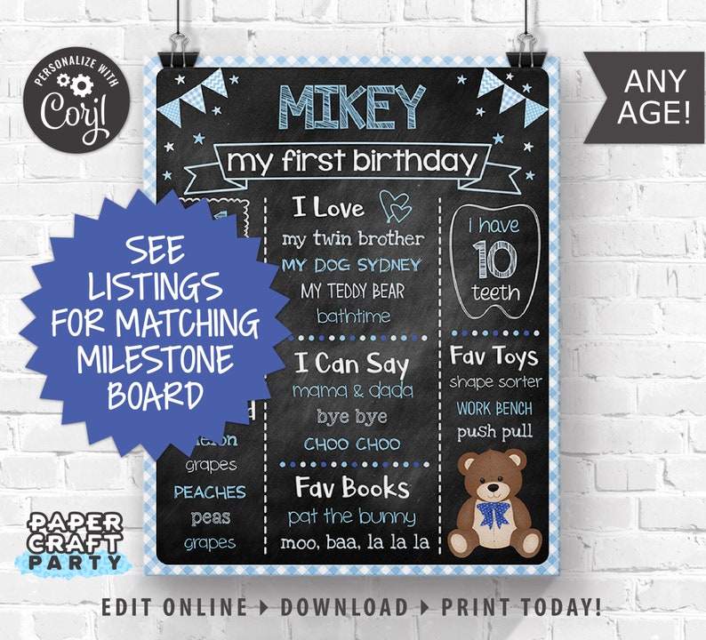 May include: A blue and white chalkboard style birthday sign with the name Mikey and the text "my first birthday". The sign lists milestones such as "I love", "I can say", "Fav toys", and "Fav books".