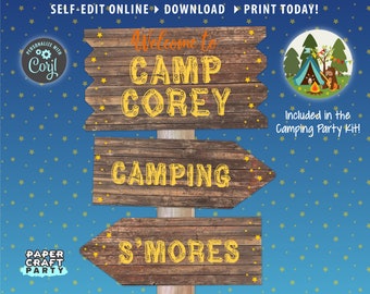 May include: A set of three wooden signs with yellow text that reads "Welcome to Camp Corey", "Camping", and "S'mores". The signs are on a blue background with yellow stars. The text "Included in the Camping Party Kit!" is at the bottom right of the image.