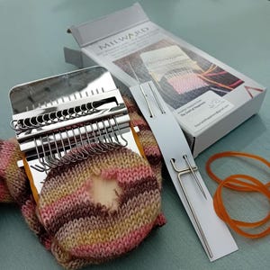 May include: A mini weaving loom kit, including a metal loom, needles, and rubber bands. The kit features a box with the text "MILWARD Mini Weaving Looms". The loom is set up on a colourful knitted sock with a hole.