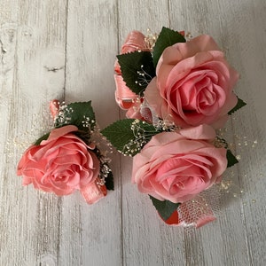Corsage and matching boutonniere designed with real touch roses in coral