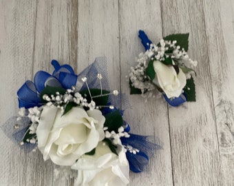 Wrist corsage and boutonniere trimmed with royal blue and silver