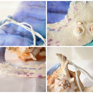 May include: A white felted fabric pouch with blue and turquoise silk accents. The pouch is decorated with small seashells and has a white drawstring closure.