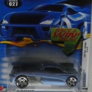 May include: A blue Hot Wheels Backdraft die-cast car in its original packaging. The packaging is blue with the Hot Wheels logo and the text "Race & Win Online". The car is a 2003 First Edition, collector number 027.