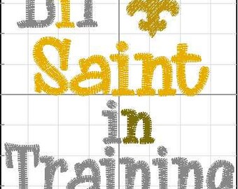May include: A gray and gold embroidery design with the text "Lil' Saint in Training" and a fleur-de-lis.