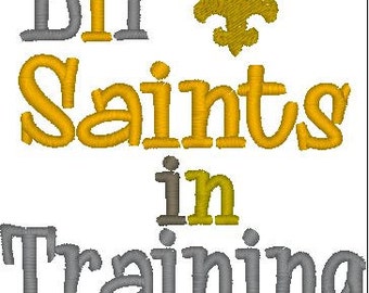 May include: Gold and gray embroidery design with the text "Lil' Saints in Training" and a fleur-de-lis.