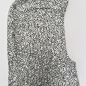 May include: A gray and white knitted balaclava hat with a fold-over brim.