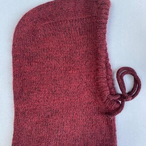 May include: A burgundy knitted balaclava with a drawstring.