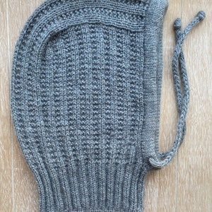 May include: Gray knitted hooded hat with a long tie string.