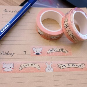 May include: Pink and white washi tape with a repeating pattern of a bear, a honeycomb, and the text "Bite Me." and "I'm a Snack."