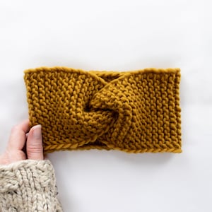 Peut inclure: Un bandeau en tricot jaune moutarde avec un nœud torsadé.
