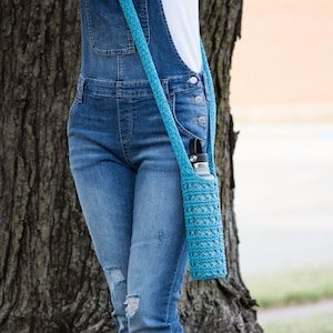 May include: A blue crocheted water bottle holder with a long strap worn over the shoulder. The holder is made of a lightweight, breathable material and is perfect for keeping your water bottle cool and refreshing.