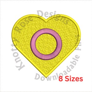 May include: A yellow heart-shaped design with a pink circle in the center. The design has a textured appearance. The text "Knotty Rose Designs" and "Downloadable Files" are in the image. The text "8 Sizes" is also in the image.