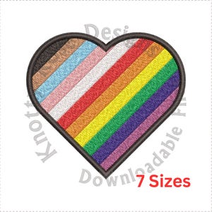 Op de afbeelding: Een hartvormige patch met een regenboogontwerp. De regenboog omvat de kleuren bruin, lichtbruin, lichtblauw, roze, wit, geel, oranje, rood, groen, paars en lichtpaars. Het hart is zwart omrand.