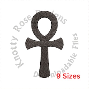 May include: A black embroidered Ankh symbol, a traditional Egyptian hieroglyph, with a circular loop at the top and a cross shape at the bottom. The symbol is surrounded by a white circle with the text "Knotty Rose Designs Downloadable Files 9 Sizes" in gray.