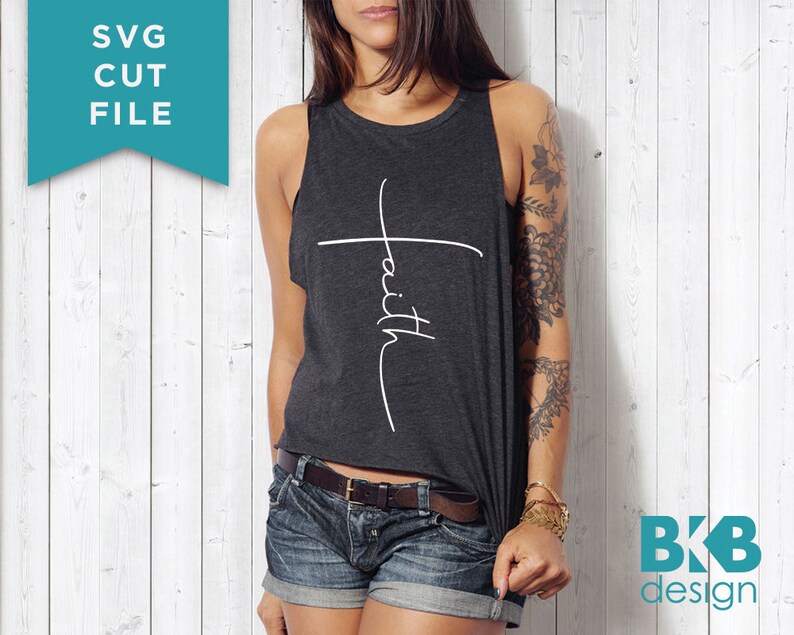 May include: A woman wearing a dark gray tank top with the word "faith" written vertically on a white cross. The tank top is cropped and the woman is wearing denim shorts.