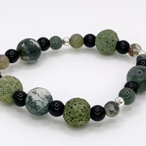 May include: A green, black, and silver beaded bracelet with lava rock, agate, and onyx beads.