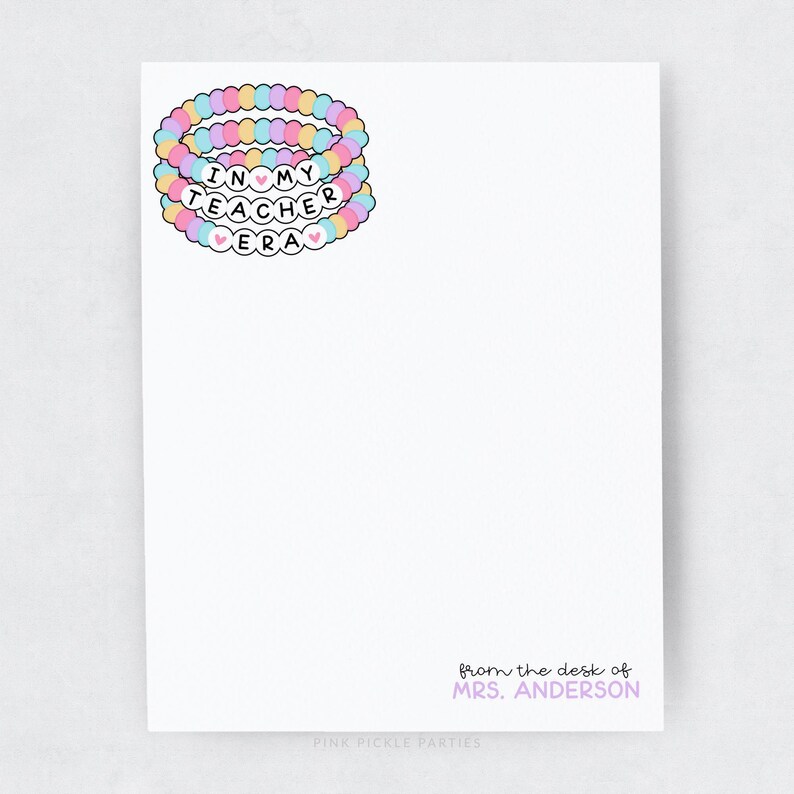 Puede incluir: Una tarjeta blanca con el texto "In My Teacher Era" en letras rosa, azul y amarillo. Las letras est&aacute;n rodeadas por una pila de tres pulseras de cuentas de colores. El texto "from the desk of MRS. ANDERSON" est&aacute; en la parte inferior de la tarjeta.