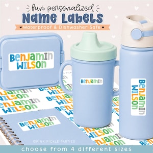 May include: A set of personalized name labels featuring the text Benjamin Wilson in blue, green, orange, and gray. The labels are applied to a light blue lunch box, a light blue sippy cup, a light blue water bottle, and a spiral notebook.
