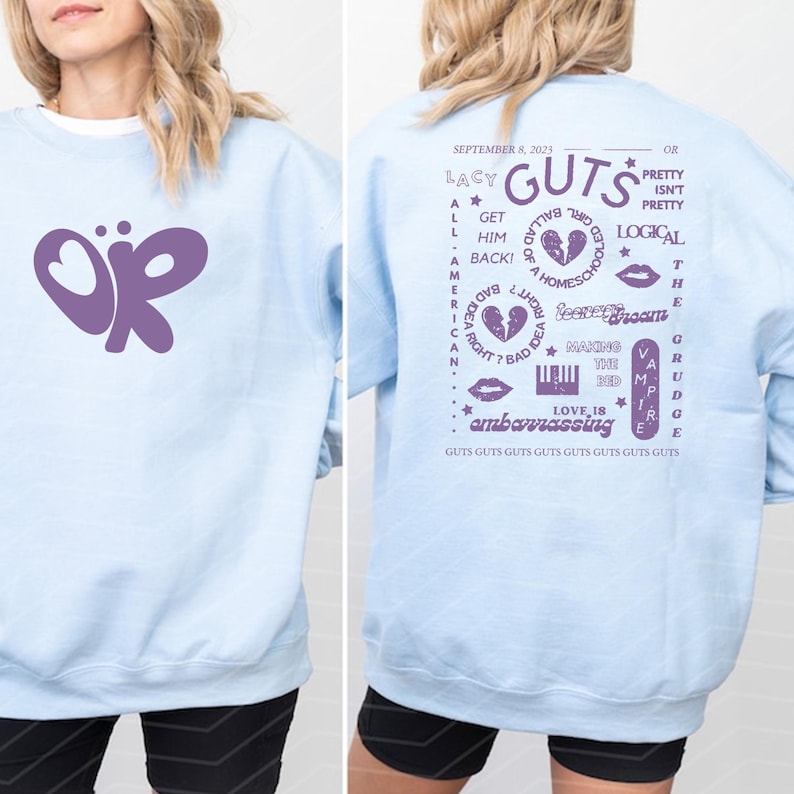 Puede incluir: Sudadera azul claro con un dise&ntilde;o de mariposa morada en la parte delantera. La parte trasera de la sudadera tiene texto morado, incluyendo "Lacy Guts" y otras frases. El dise&ntilde;o es informal.