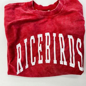 May include: Red sweatshirt with the word "RICEBIRDS" printed in white on the front.