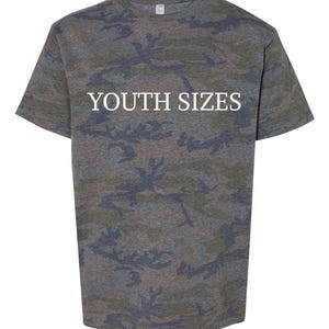 May include: A short-sleeved t-shirt featuring a camouflage pattern in shades of green, brown, and dark gray. The text YOUTH SIZES is printed in white capital letters across the center of the chest area on the front of the garment.