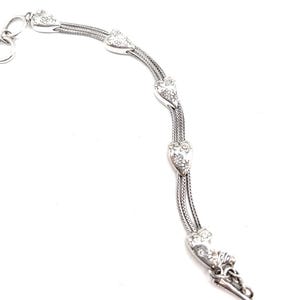 May include: A silver watch chain with a heart-shaped design. The chain has a decorative floral pattern and a key ring.