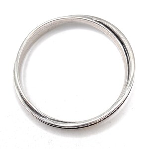 Peut inclure: Une bague en argent avec un design simple et &eacute;l&eacute;gant. La bague est compos&eacute;e de deux bandes entrelac&eacute;es.