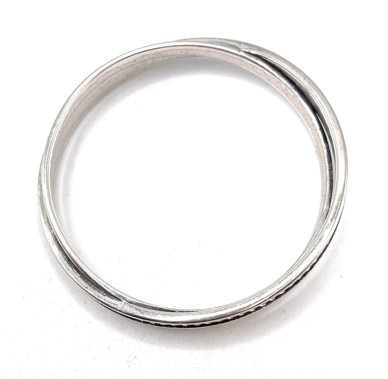 Peut inclure: Une bague en argent avec un design simple et &eacute;l&eacute;gant. La bague est compos&eacute;e de deux bandes entrelac&eacute;es.