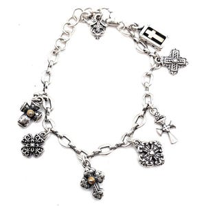 May include: A silver charm bracelet with multiple cross-shaped charms, including a small gold cross charm.