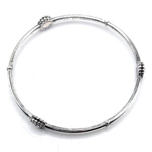 Puede incluir: Un brazalete de plata con cuatro acentos redondos texturizados.