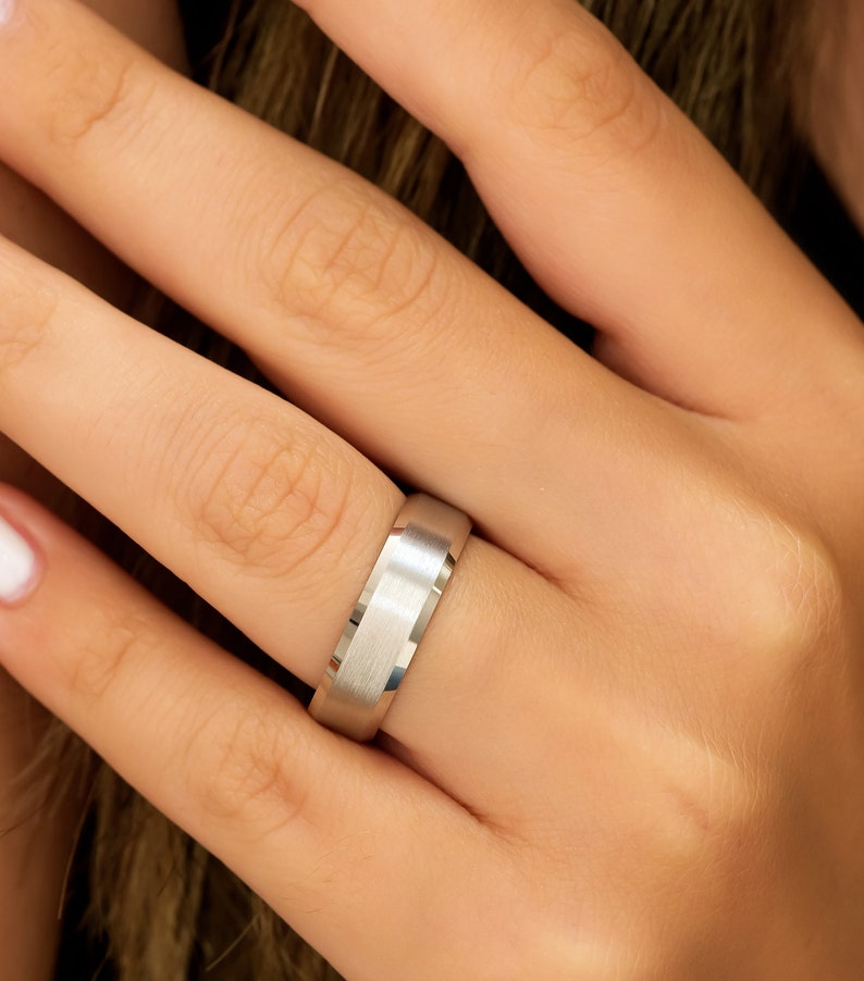 May include: A silver wedding band with a brushed finish.