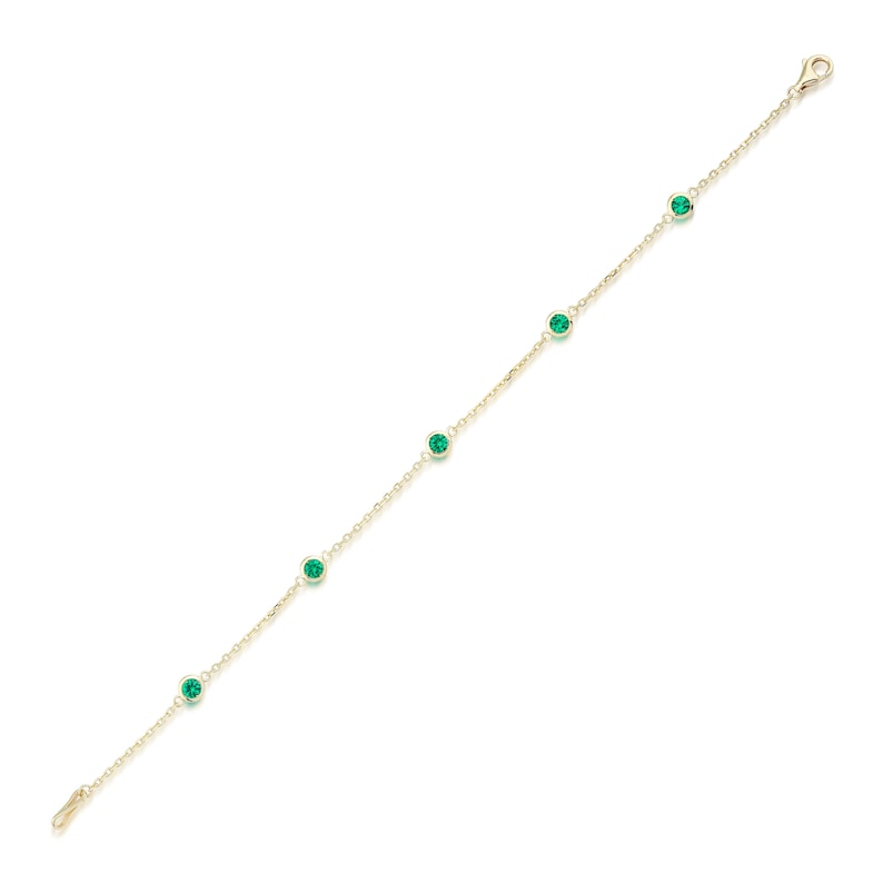 Puede incluir: Un brazalete de cadena dorada con cinco piedras preciosas verdes.