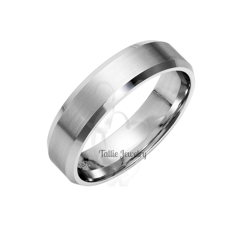May include: A silver wedding band with a beveled edge and a brushed finish.